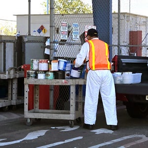 A City worker unloading unused paint from a truck