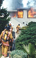 Photo of firefighters and a burning house