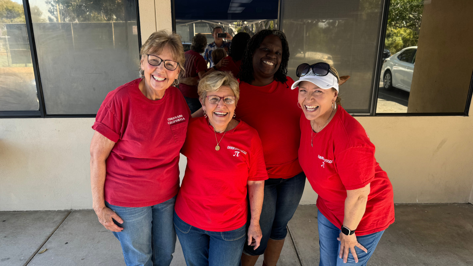 four women in red shirts smiling 