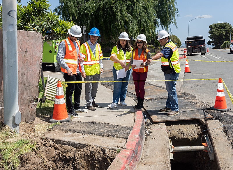 City staff inspecting the construction of a sidewalk at a corner on Encinitas Avenue