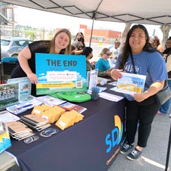 City staff handing out flyers at a information booth