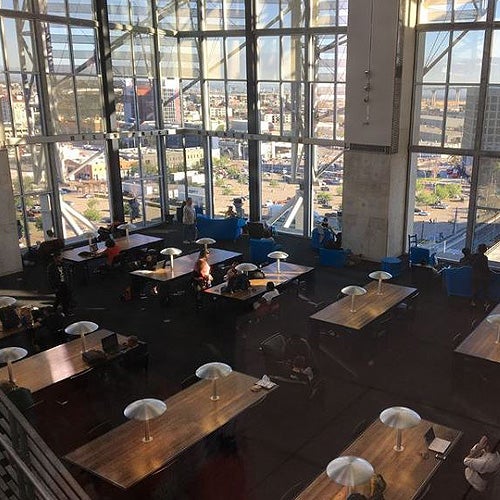 Patrons using tables in Central Library with a view of downtown outside the windows