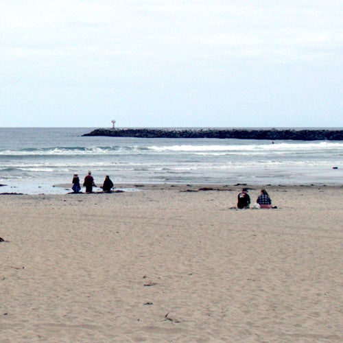 People enjoying the beach on a cloudy day