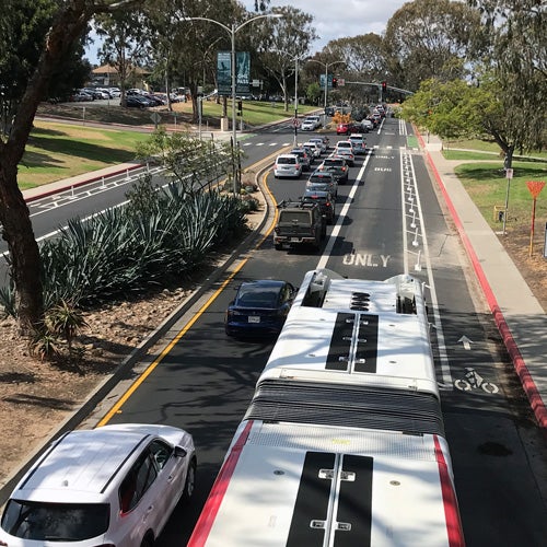 Cars and a bus sharing the road with a dedicated bike lane 