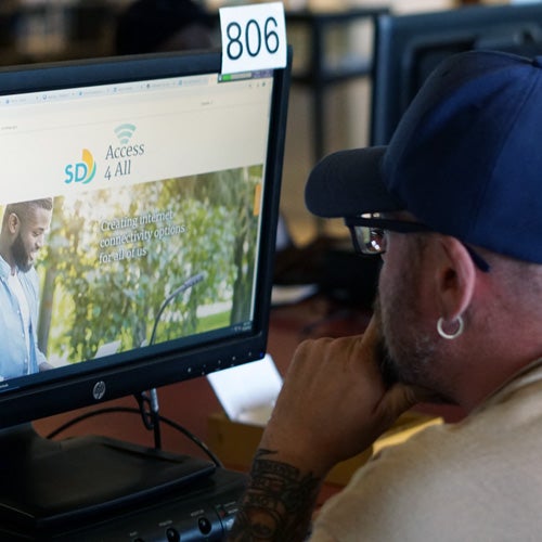 A library patron using a computer to view the SD Access 4 All website