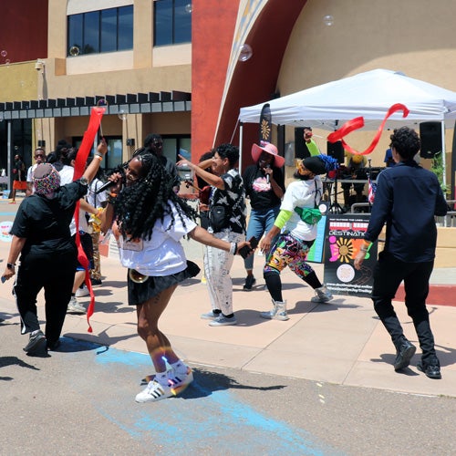 A person singing with people dancing in the background