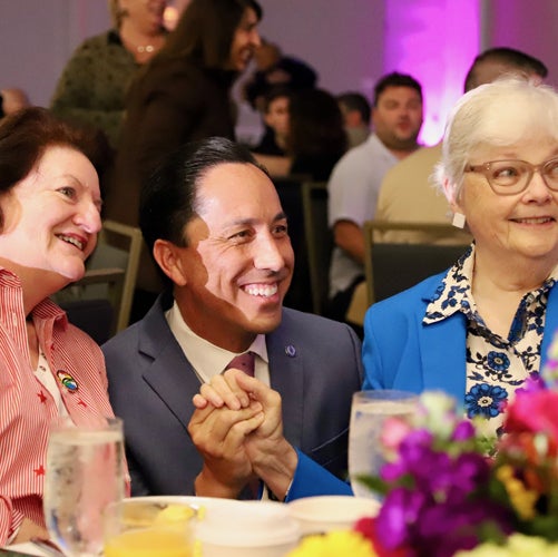Mayor Todd Gloria presenting a plaque on a stage