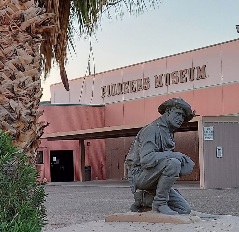 A statue of a pioneer in front of the Pioneers Museum