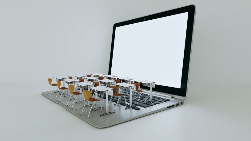 Computer screen with desks and tables on top of a laptop's keyboard.