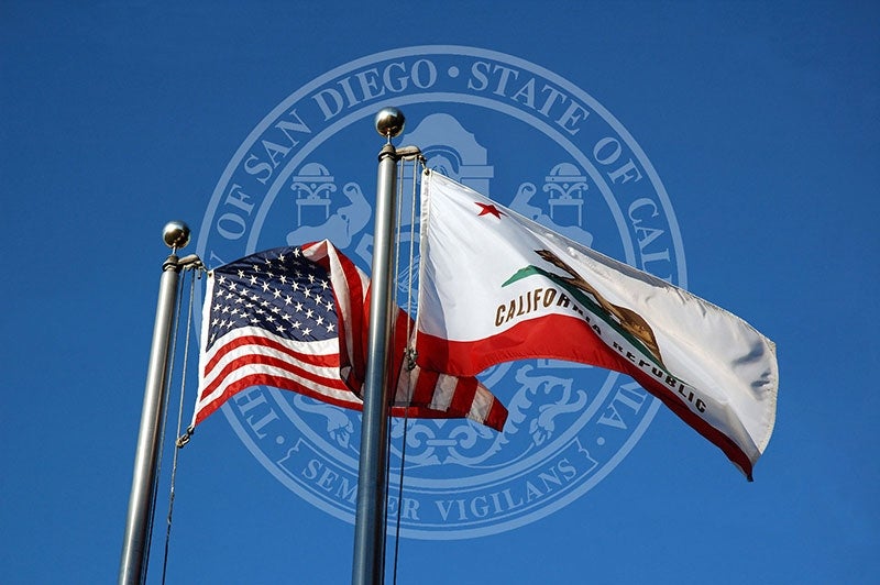 The US and California flags overlayed on the City seal