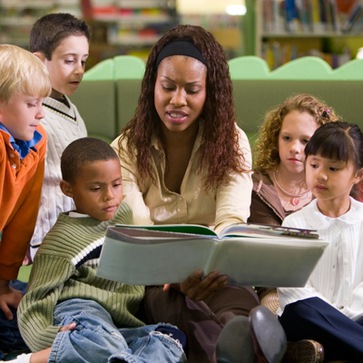 Image of person reading books to children