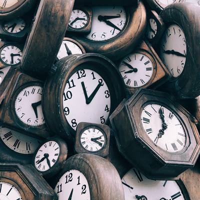 Image of many wooden clocks on top of each other