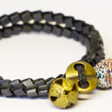 Black double beaded bracelet with gold and ceramic charms