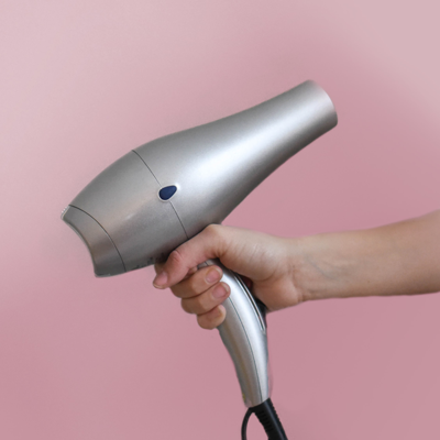 Hand holding a silver hair dryer