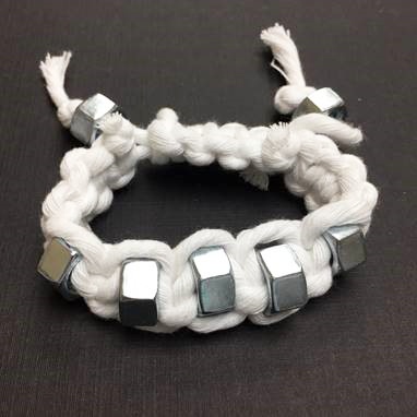 Bracelet made out of white string and hex nuts