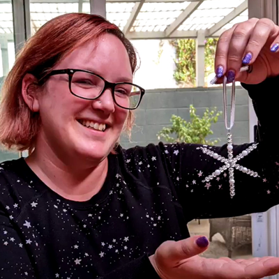 Library staff demonstrating how to create a snowflake decoration