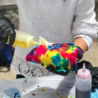 Image of a person tie dyeing a shirt