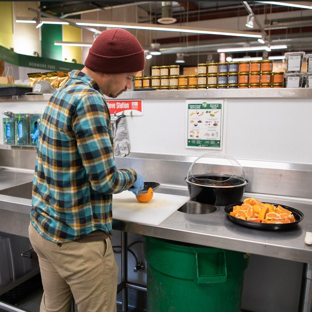 Person cutting an orange in a restaurant kitchen