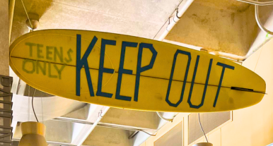 Closeup of surfboard sign located in the 2nd floor Pauline Foster Teen Center with the words "Teens Only" and "Keep Out" written on it