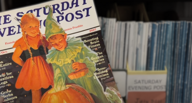 Closeup of a vintage Saturday Evening Post magazine cover showing kids illustrated in Halloween costumes, from the magazine stacks on the third floor