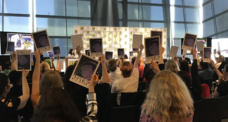 Comic-Con at the library attendees holding up coming books