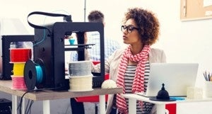 a person working on a 3d printer and computer