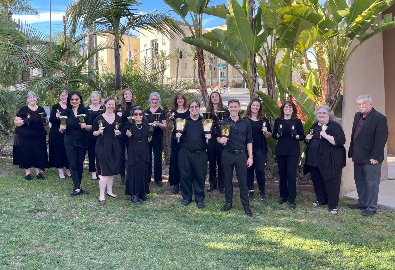 San Diego Harmony Ringers posing front of palm trees