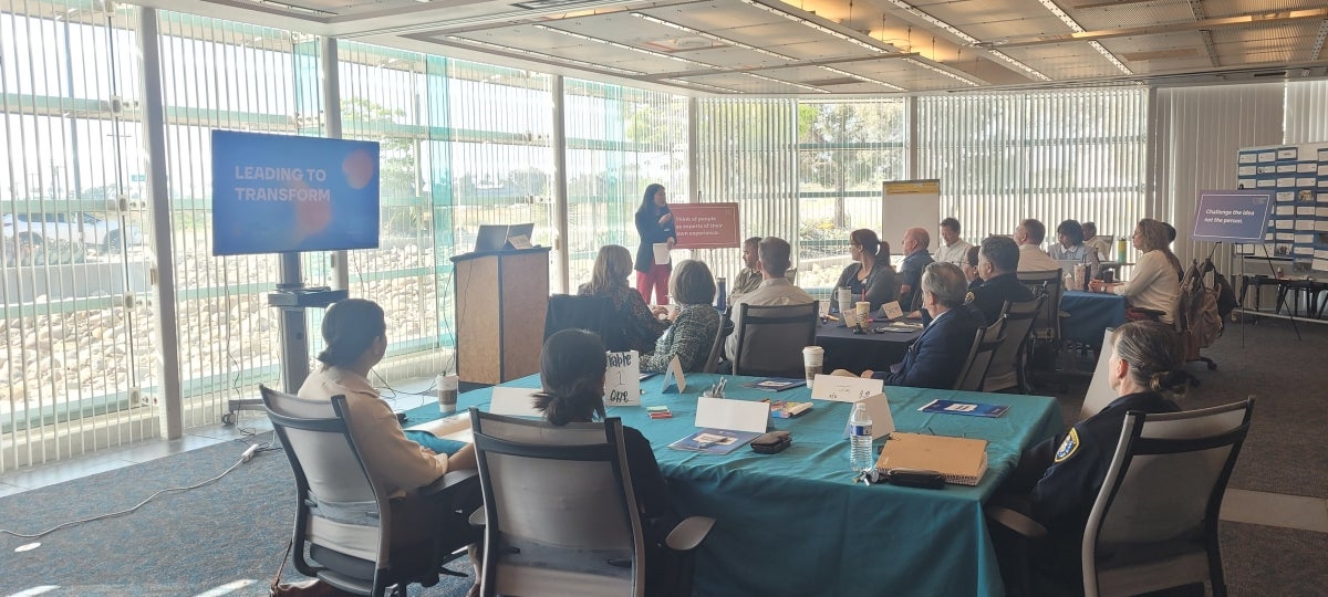 Training with the Race and Equity Department, led by Lisa Ann Kim. There are many people in attendance, watching attentively.