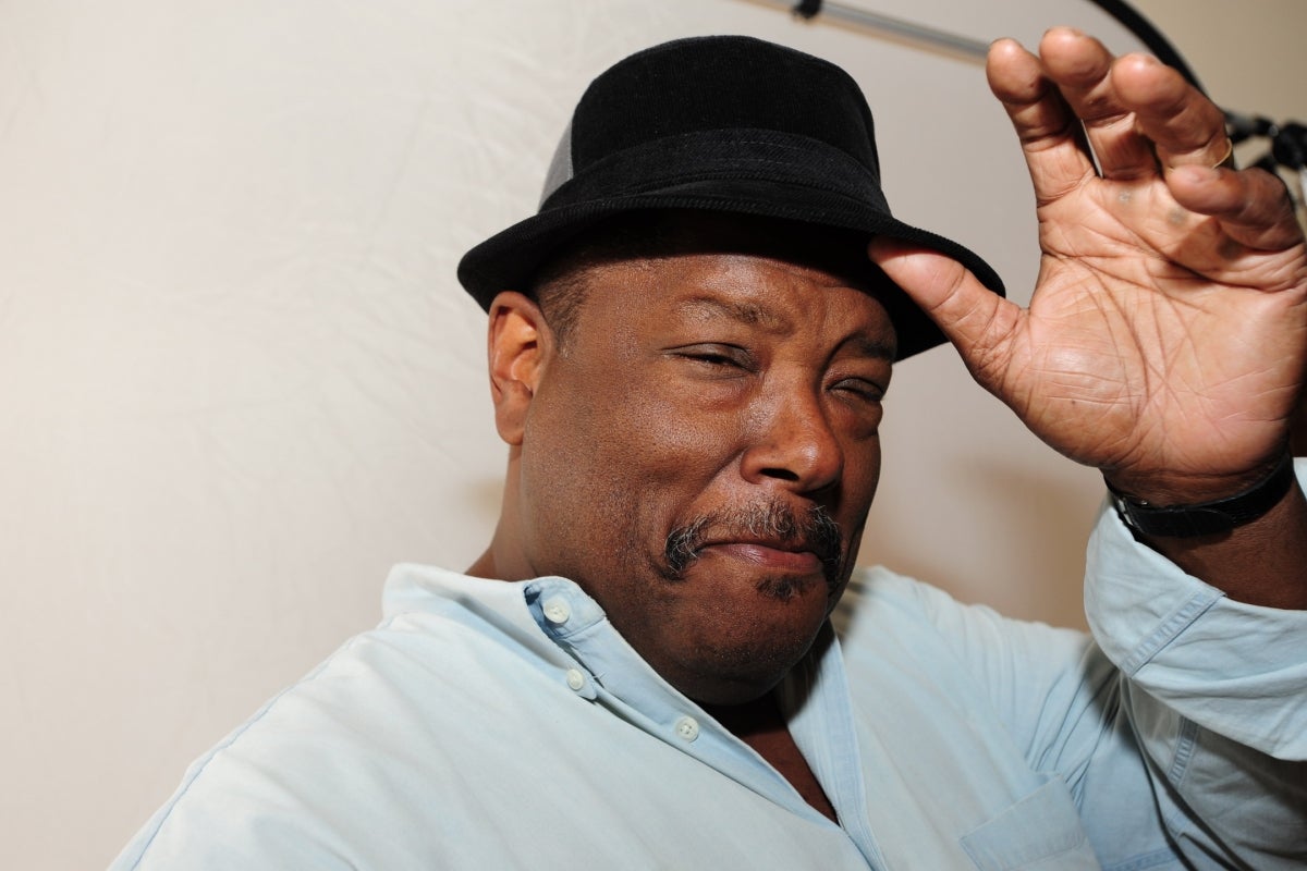 Headshot of writer Gary Phillips in a white button down shirt with a black fedora.