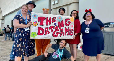 Library staff posing with a banner that reads "The Dating Game"